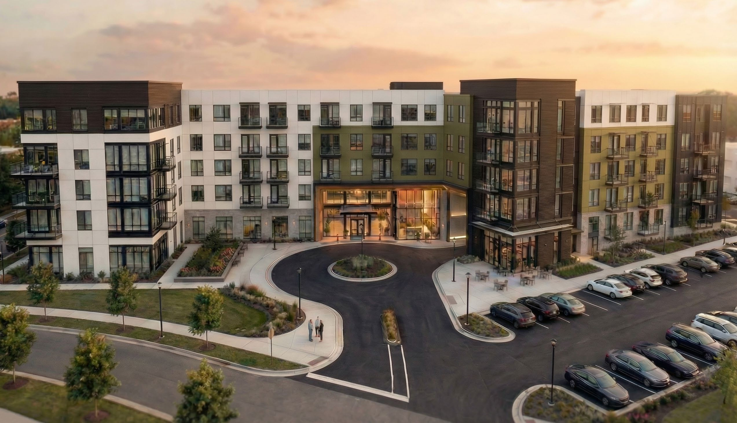 Ground-level rendering of the approved Ashford Green apartment building's entrance, lobby, and drop-off court at dusk.