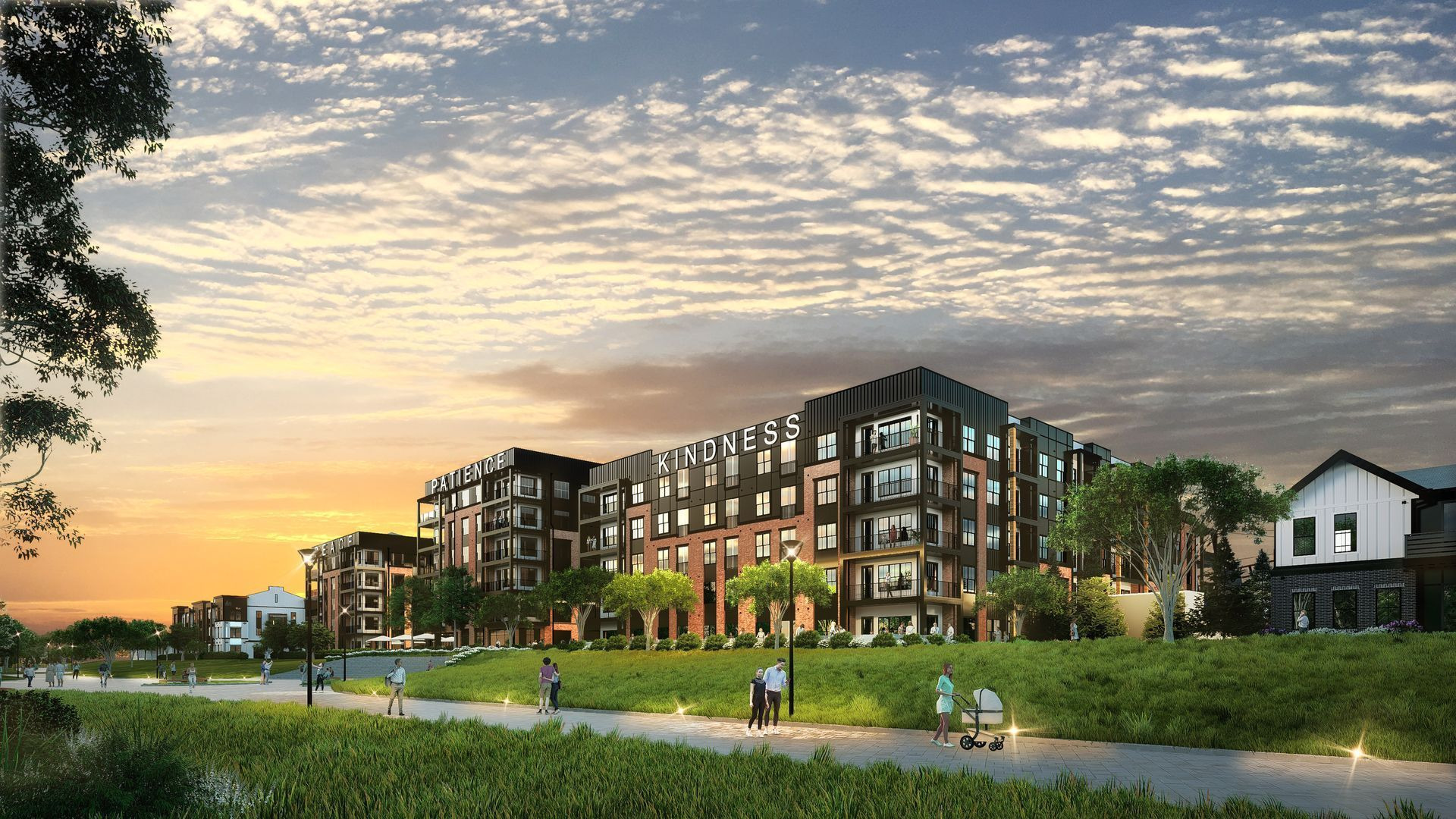 Modern apartment buildings at sunset beside a green lawn and path with a few people walking